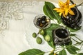 Teapot with a glass jar jamÃÂ ofÃÂ nuts on leaves with orange lilies on an embroidered tablecloth